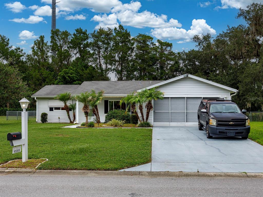 10285 Southeast 176th Street Summerfield, FL 34491 - Photo 1 of 29 a car parked in front of a house with a yard