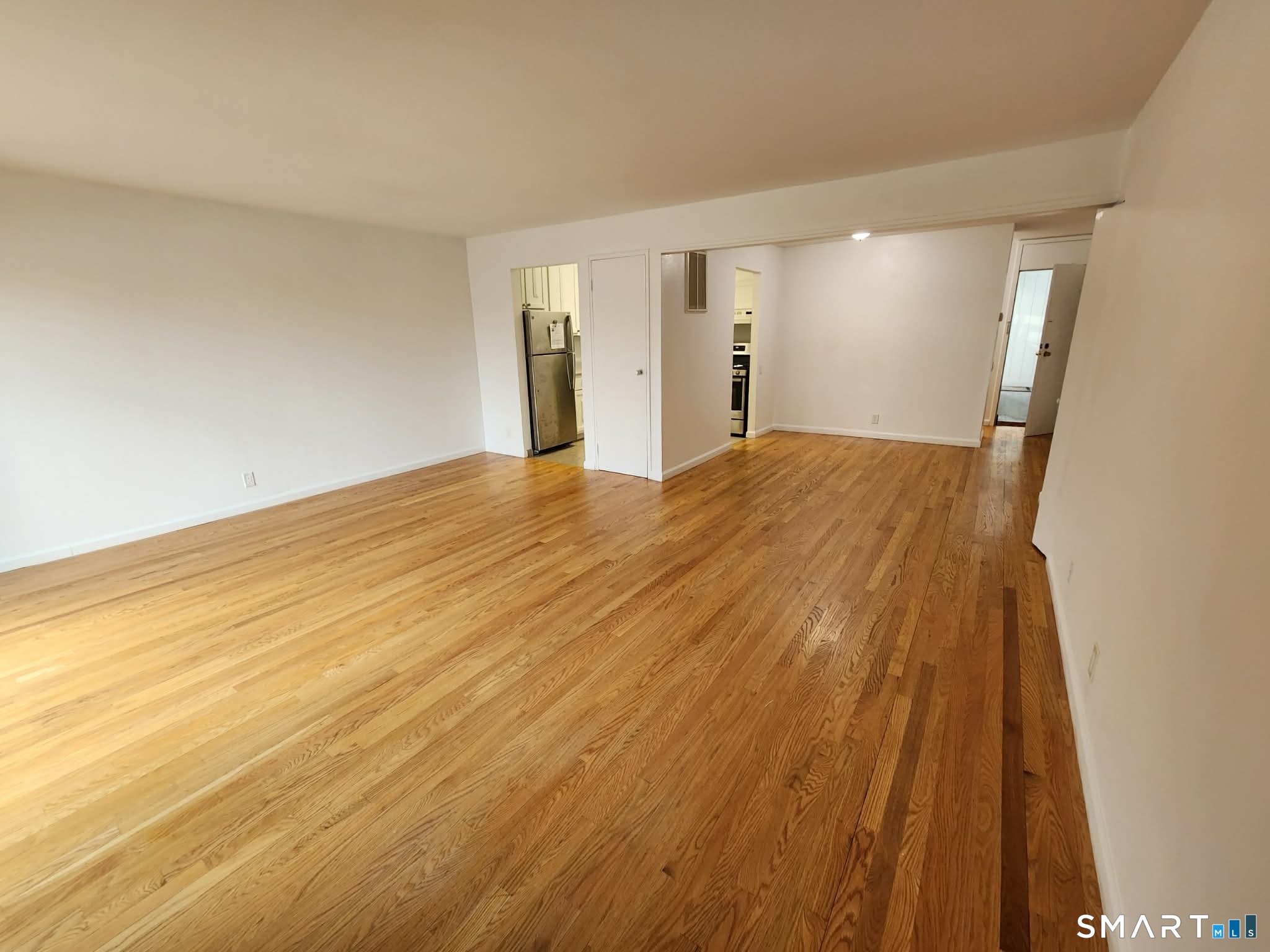 a view of empty room with wooden floor
