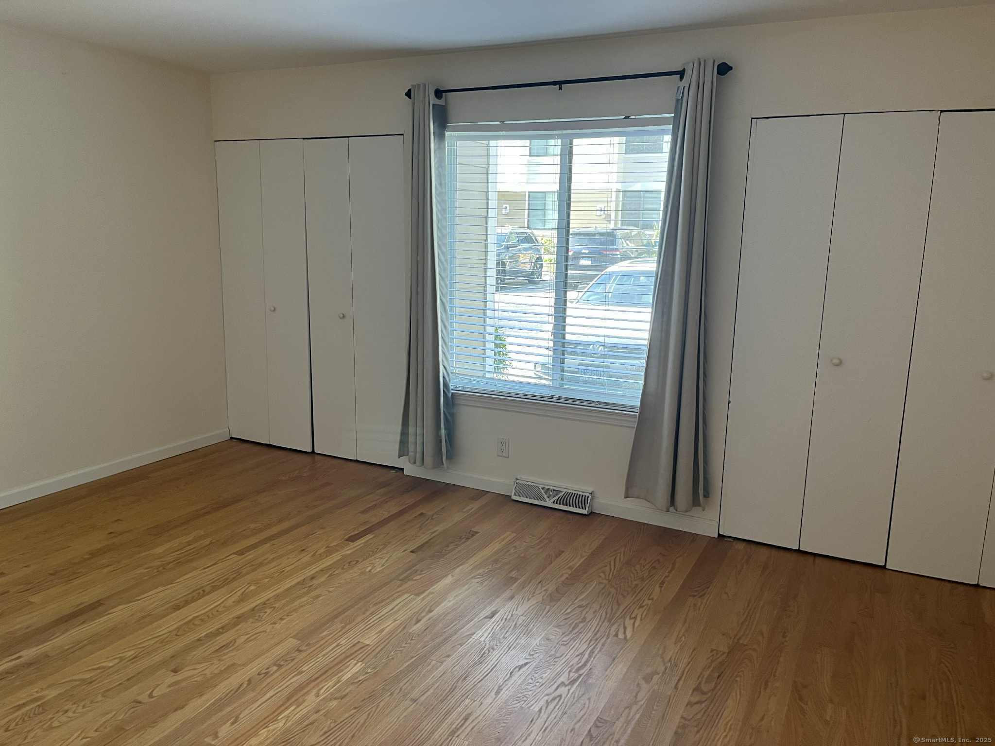 2 Cook Close, Unit 2 Ridgefield, CT 06877 - Photo 10 of 24 a view of an empty room with wooden floor and a window