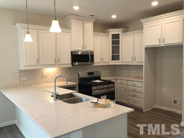 6000 Beale Loop Raleigh, NC 27616 - Photo 3 of 16 a kitchen with kitchen island granite countertop a sink a stove and cabinets