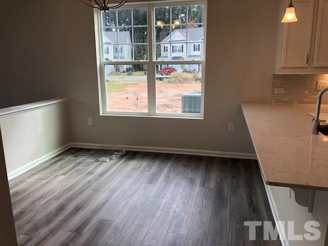 6000 Beale Loop Raleigh, NC 27616 - Photo 5 of 16 an empty room with wooden floor and windows