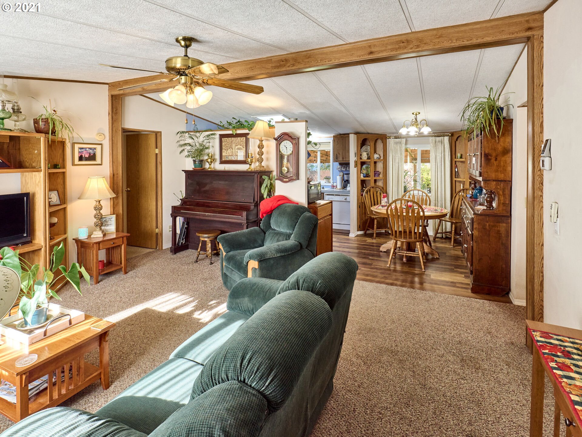 913 Toliver Road, Unit B Molalla, OR 97038 - Photo 4 of 26 a living room with furniture a chandelier and a flat screen tv