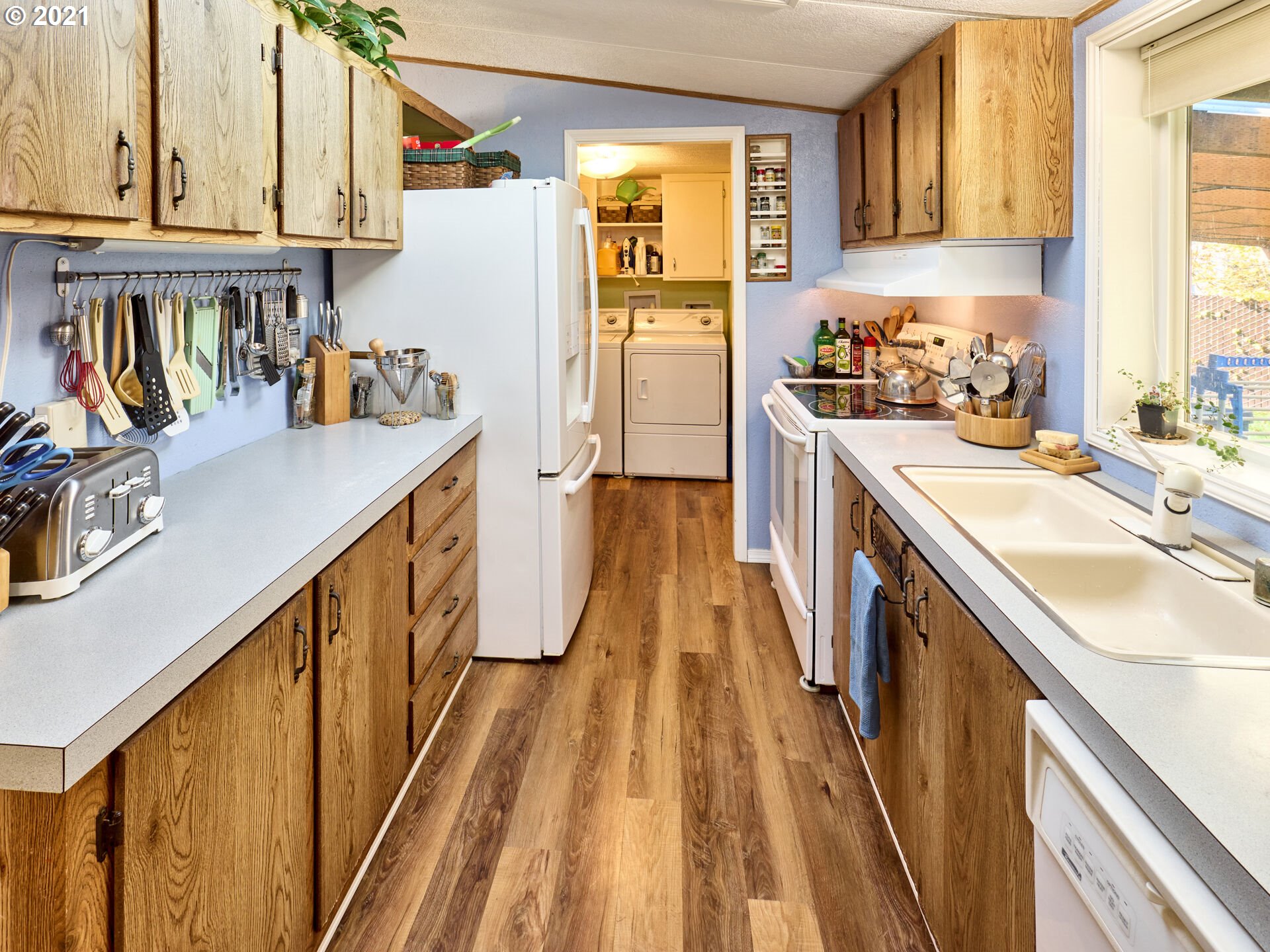 913 Toliver Road, Unit B Molalla, OR 97038 - Photo 9 of 26 a kitchen with a sink a refrigerator a stove and wooden floor