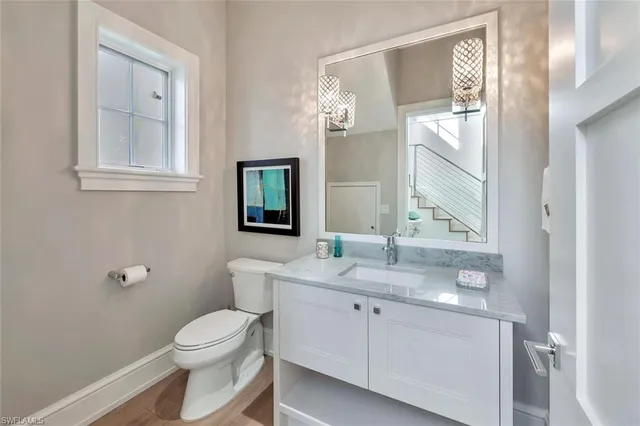a bathroom with a toilet a sink and mirror