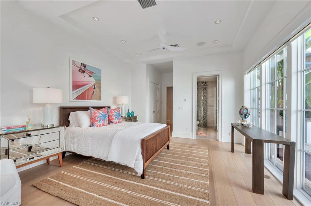 982 9th Avenue South Naples, FL 34102 - Photo 26 of 48 a bedroom with a large bed and a chandelier