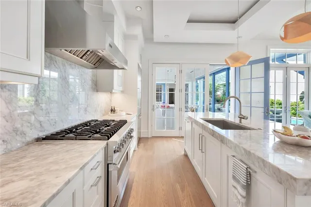 a kitchen with stainless steel appliances a sink a stove and a wooden floors