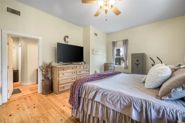 a bedroom with a bed and a flat tv screen on dresser