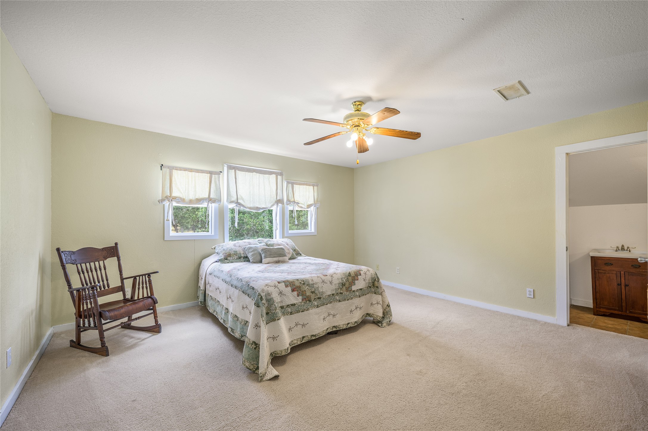 4310 Leslie Road Fayetteville, TX 78940 - Photo 17 of 22 a bedroom with a bed a chair and potted plant on the dresser