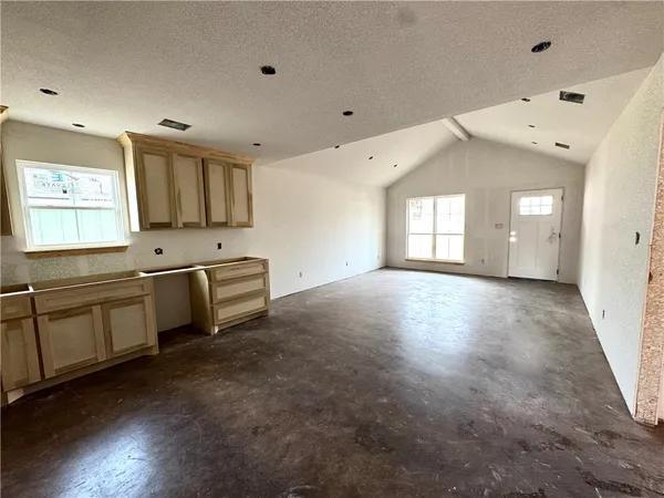 a large white kitchen with a sink and dishwasher a stove top oven with wooden floor