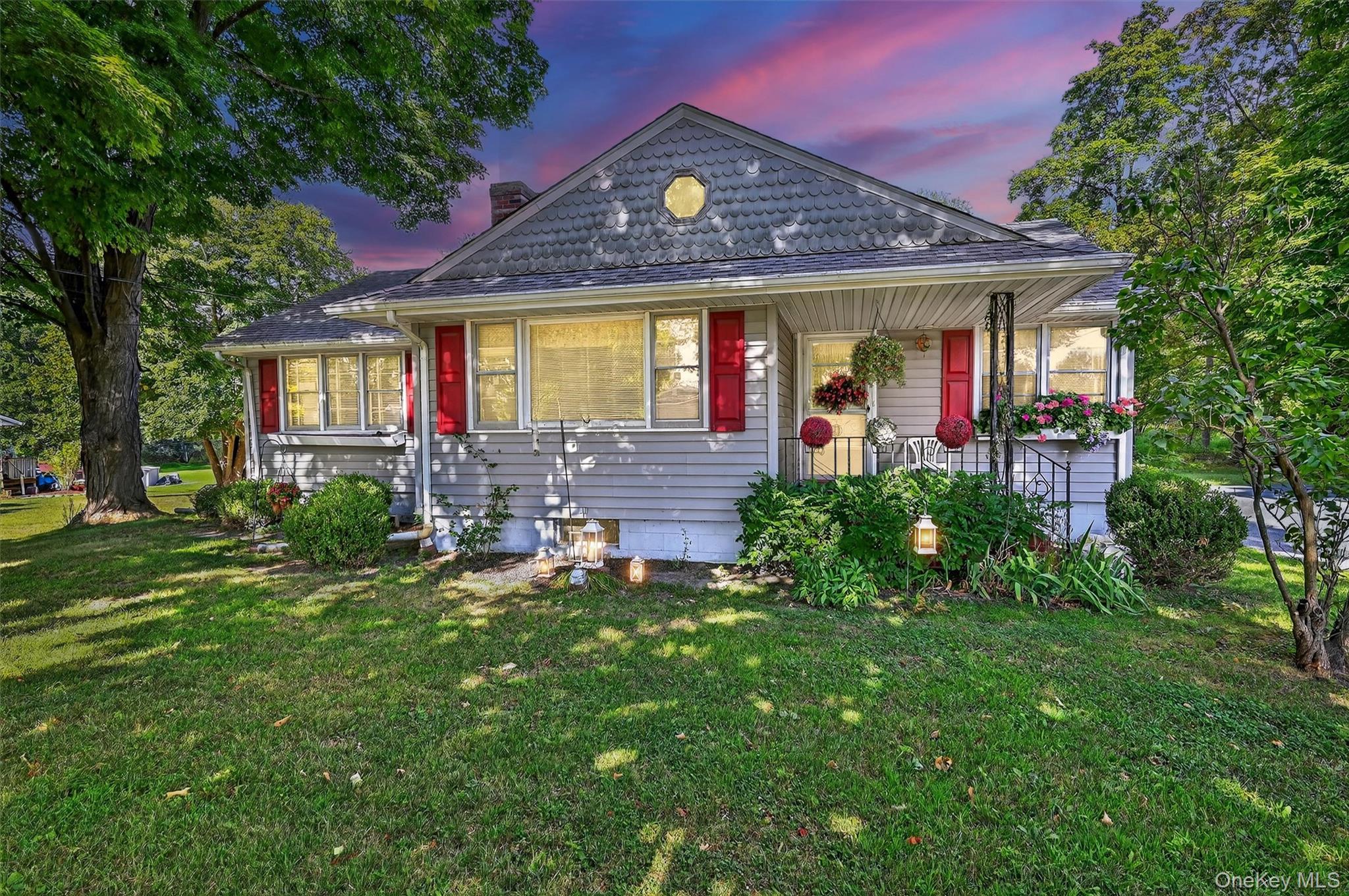 a view of a house with a big yard and large tree