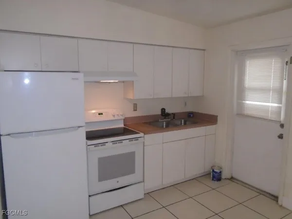 a kitchen with granite countertop white cabinets and white appliances