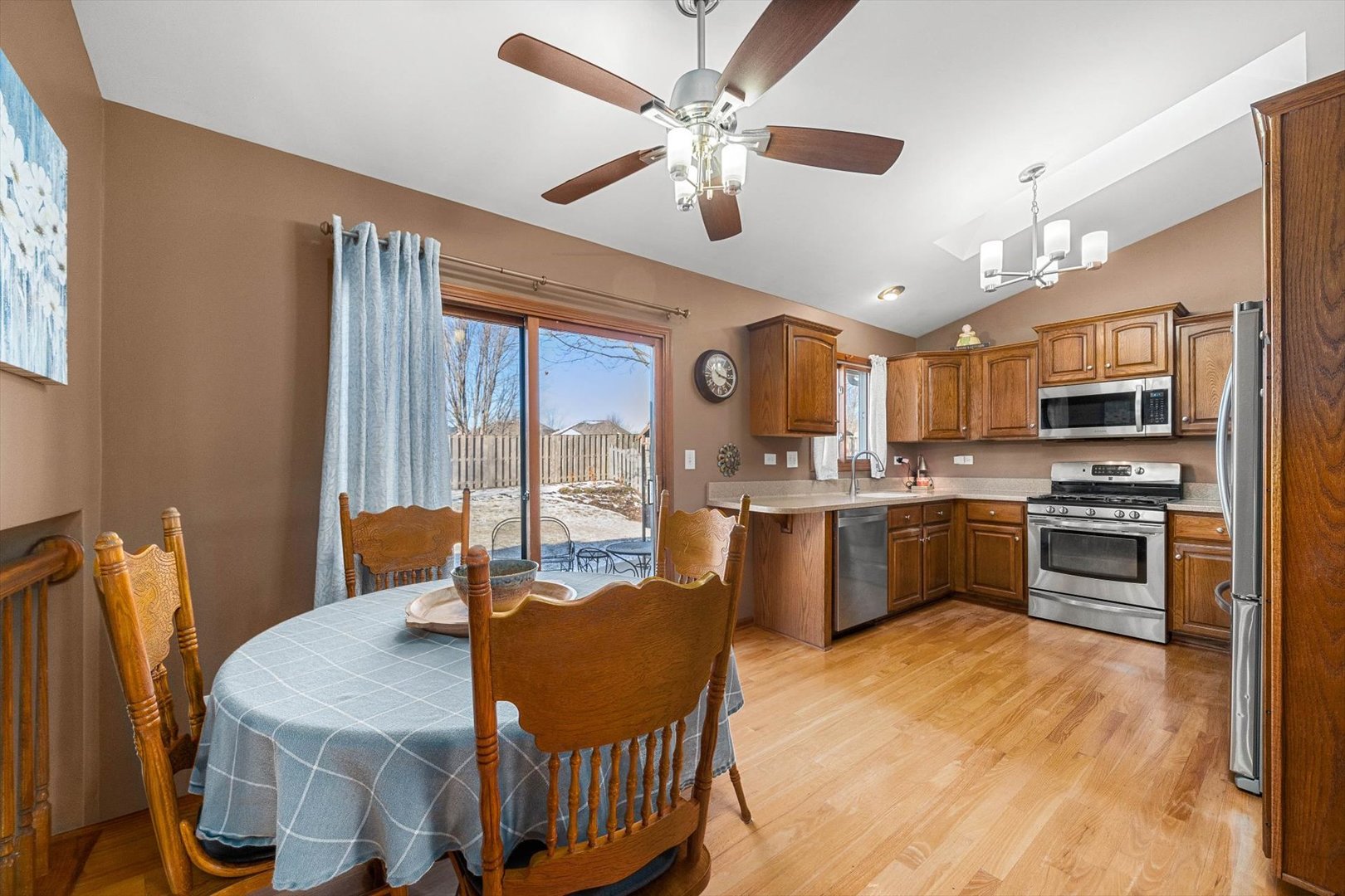 431 Badger Lane Oswego, IL 60543 - Photo 4 of 19 a kitchen with stainless steel appliances kitchen island granite countertop a table chairs microwave and sink