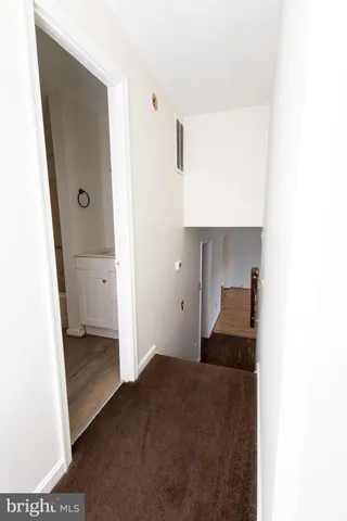 a living room with a bed and a walk in closet with wooden floor