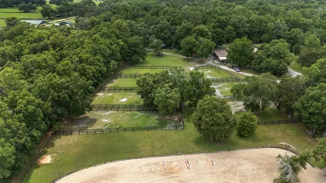 an aerial view of residential houses with outdoor space and trees