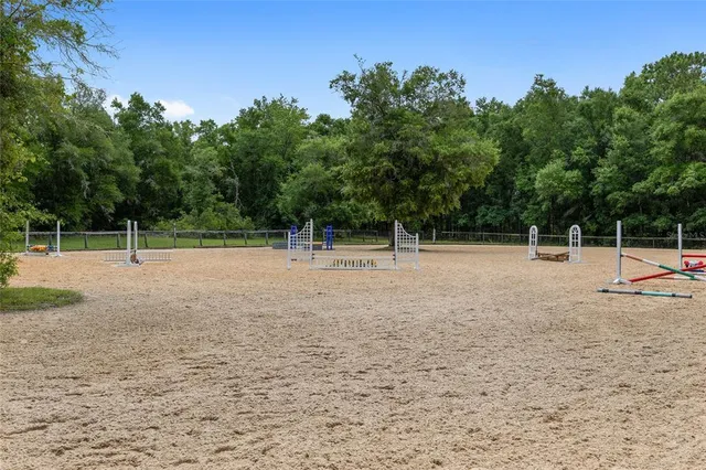 an aerial view of green landscape with trees houses and lake view