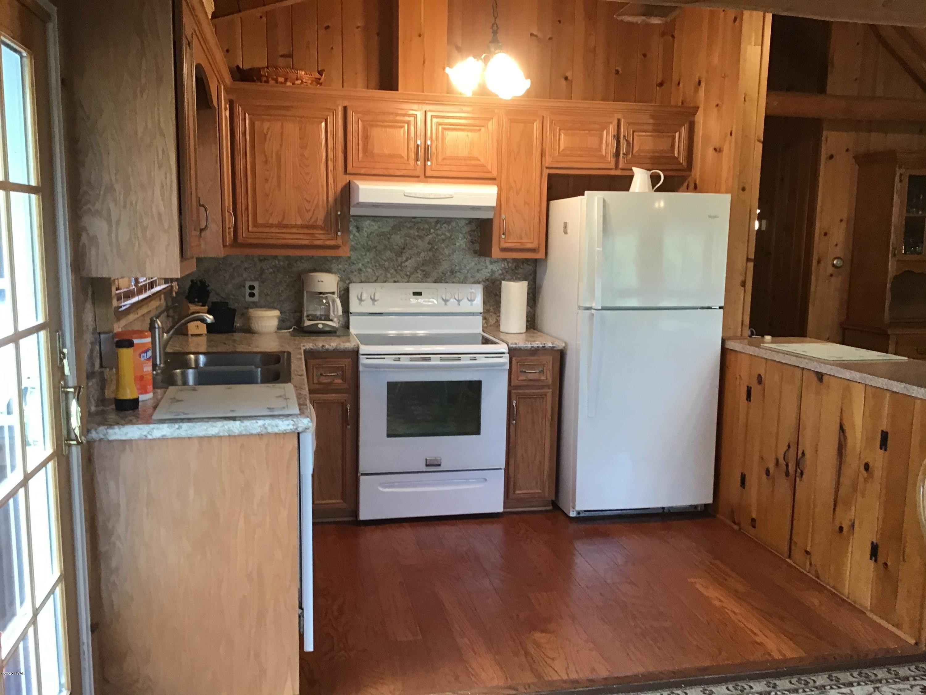 107 Maple Ridge Drive Hawley, PA 18428 - Photo 11 of 32 a kitchen with a refrigerator a stove a microwave and cabinets