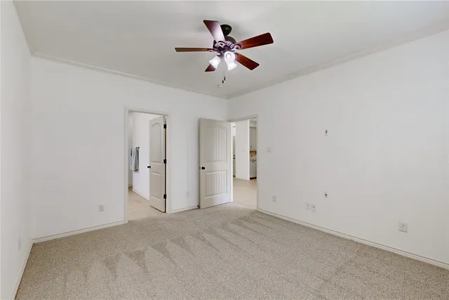 an empty room with closet and ceiling fan