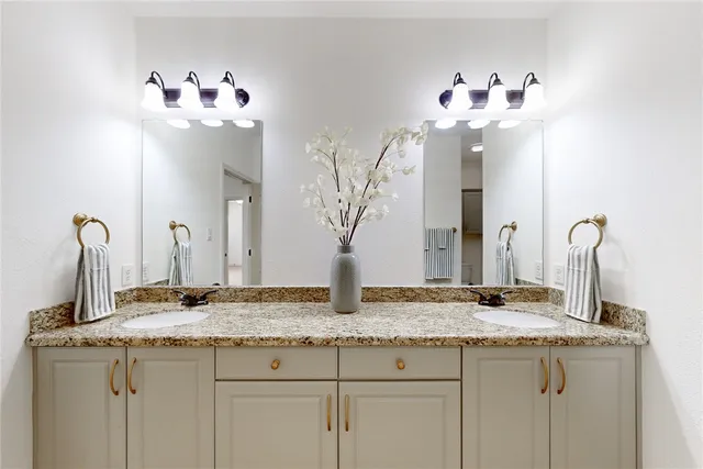 a bathroom with a granite counter top a sink and a mirror