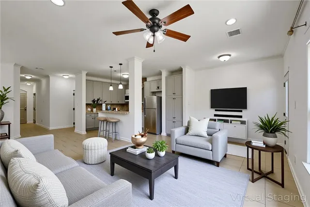 a living room with furniture kitchen view and a flat screen tv