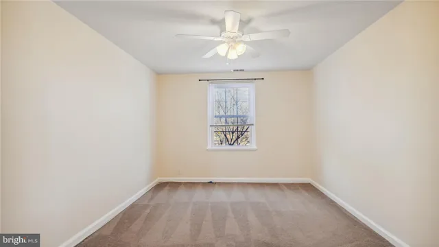 an empty room with a chandelier fan