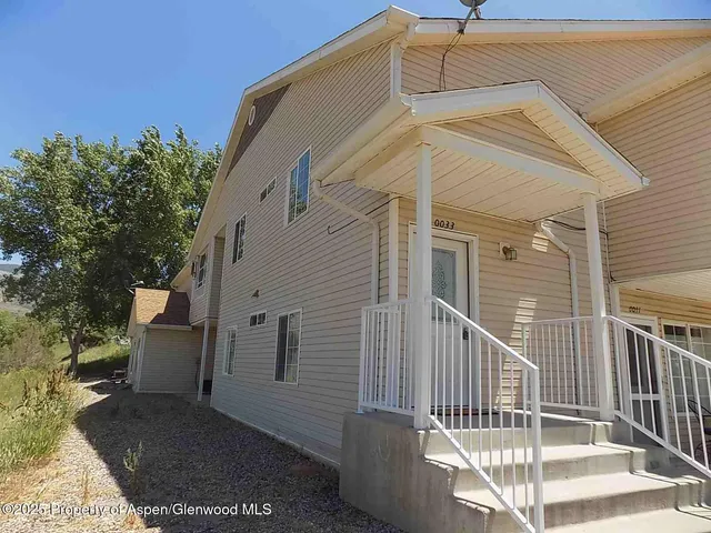 a view of a white house with iron fence