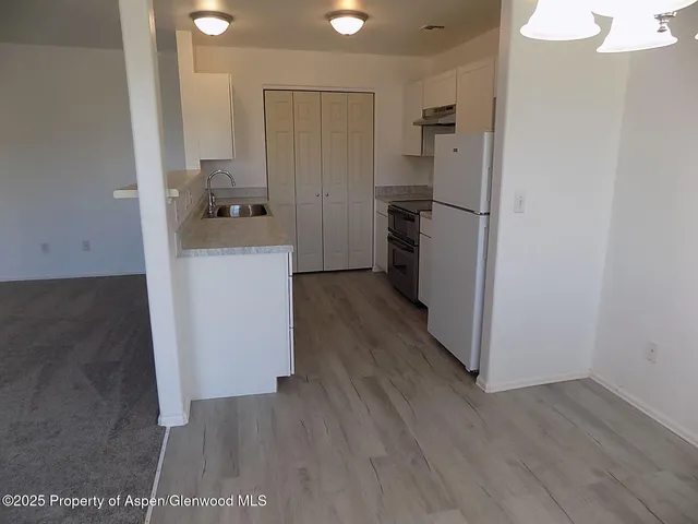 a kitchen with a refrigerator and a stove top oven