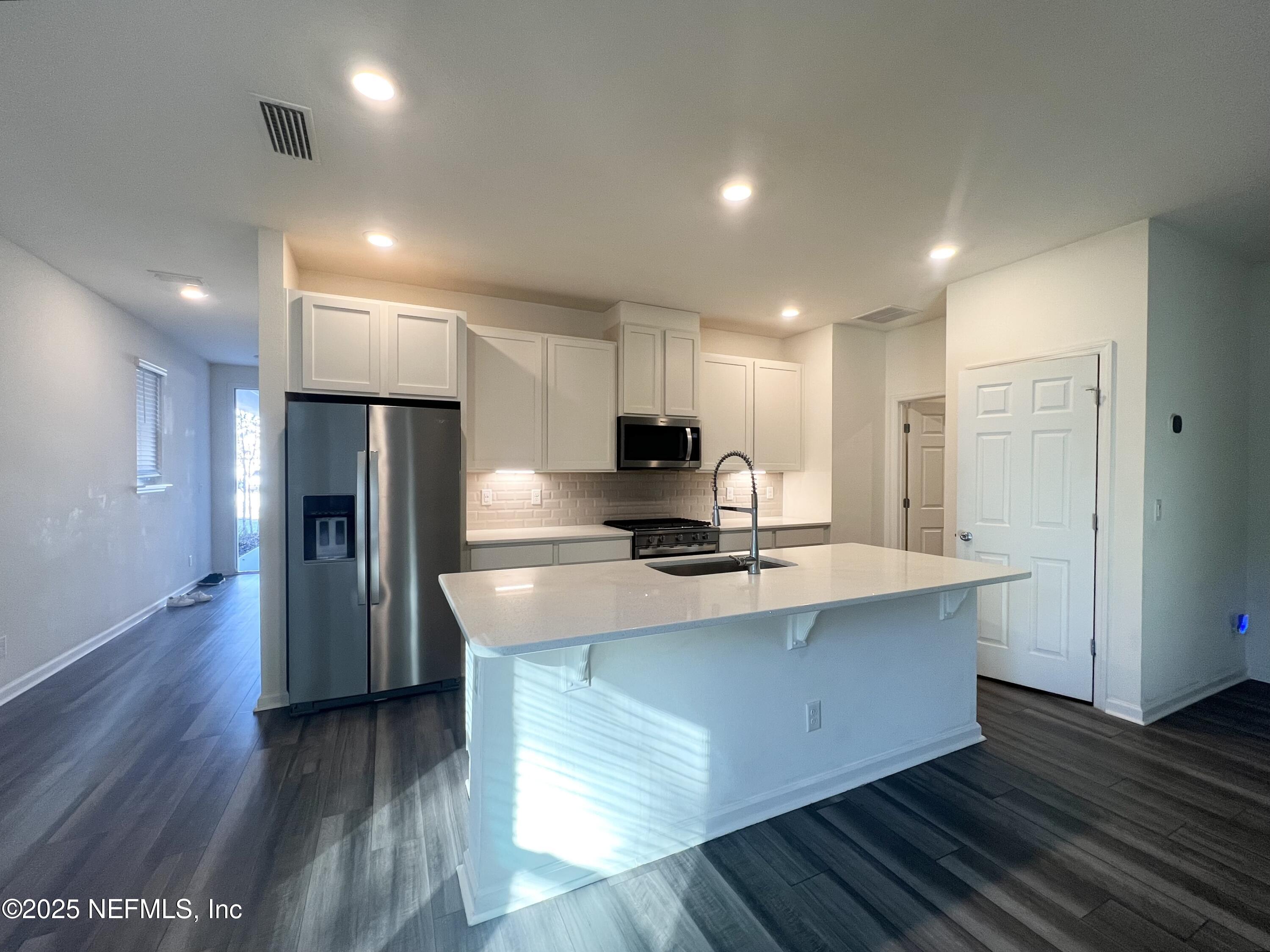 216 Rambling Brk Trail St. Johns, FL 32259 - Photo 4 of 24 a kitchen with stainless steel appliances granite countertop a sink a stove a refrigerator and a microwave