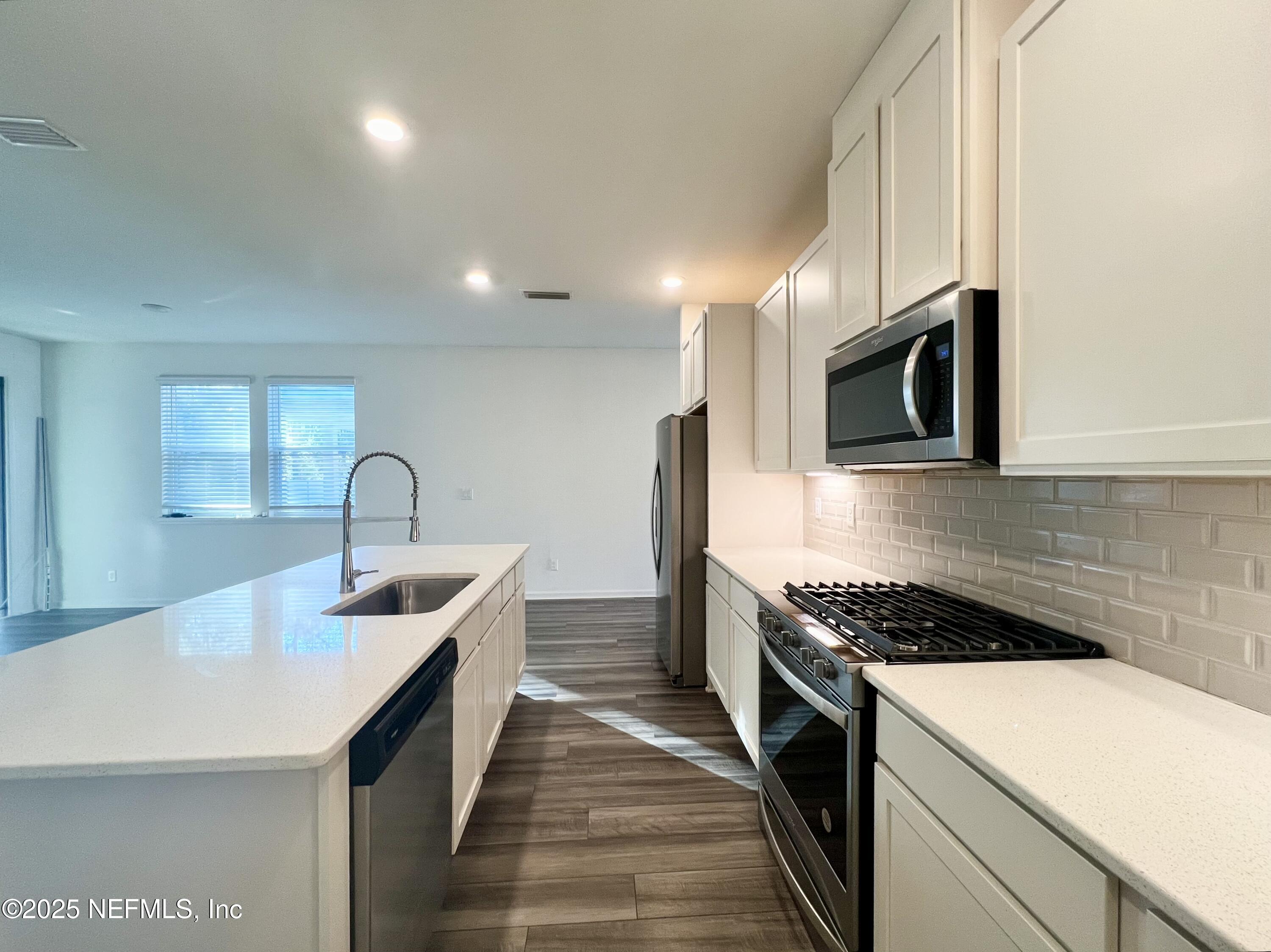 216 Rambling Brk Trail St. Johns, FL 32259 - Photo 6 of 24 a kitchen with kitchen island granite countertop a sink and stainless steel appliances