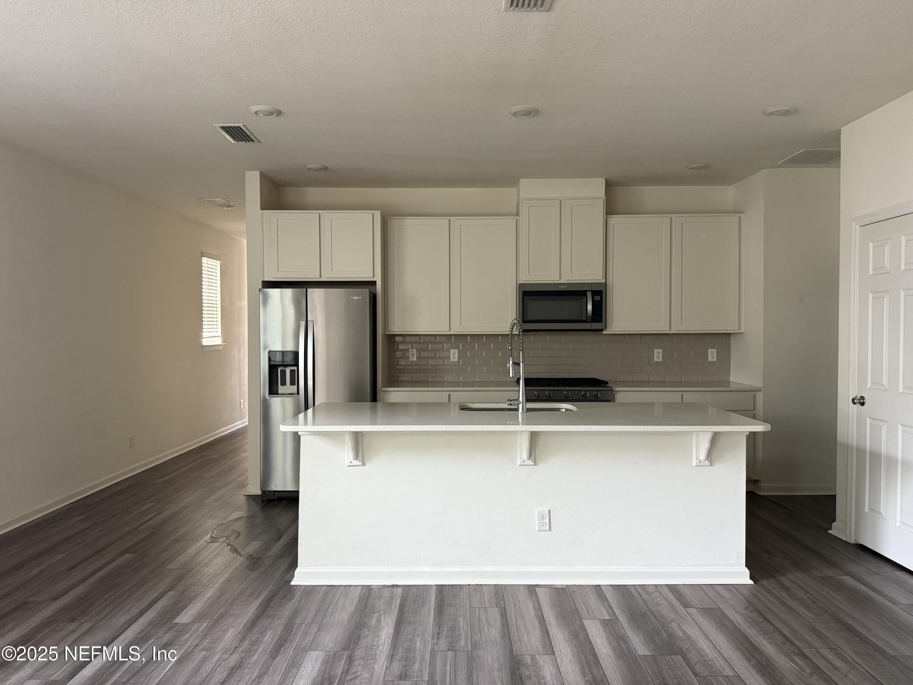 216 Rambling Brk Trail St. Johns, FL 32259 - Photo 7 of 24 a kitchen with kitchen island wooden cabinets and stainless steel appliances