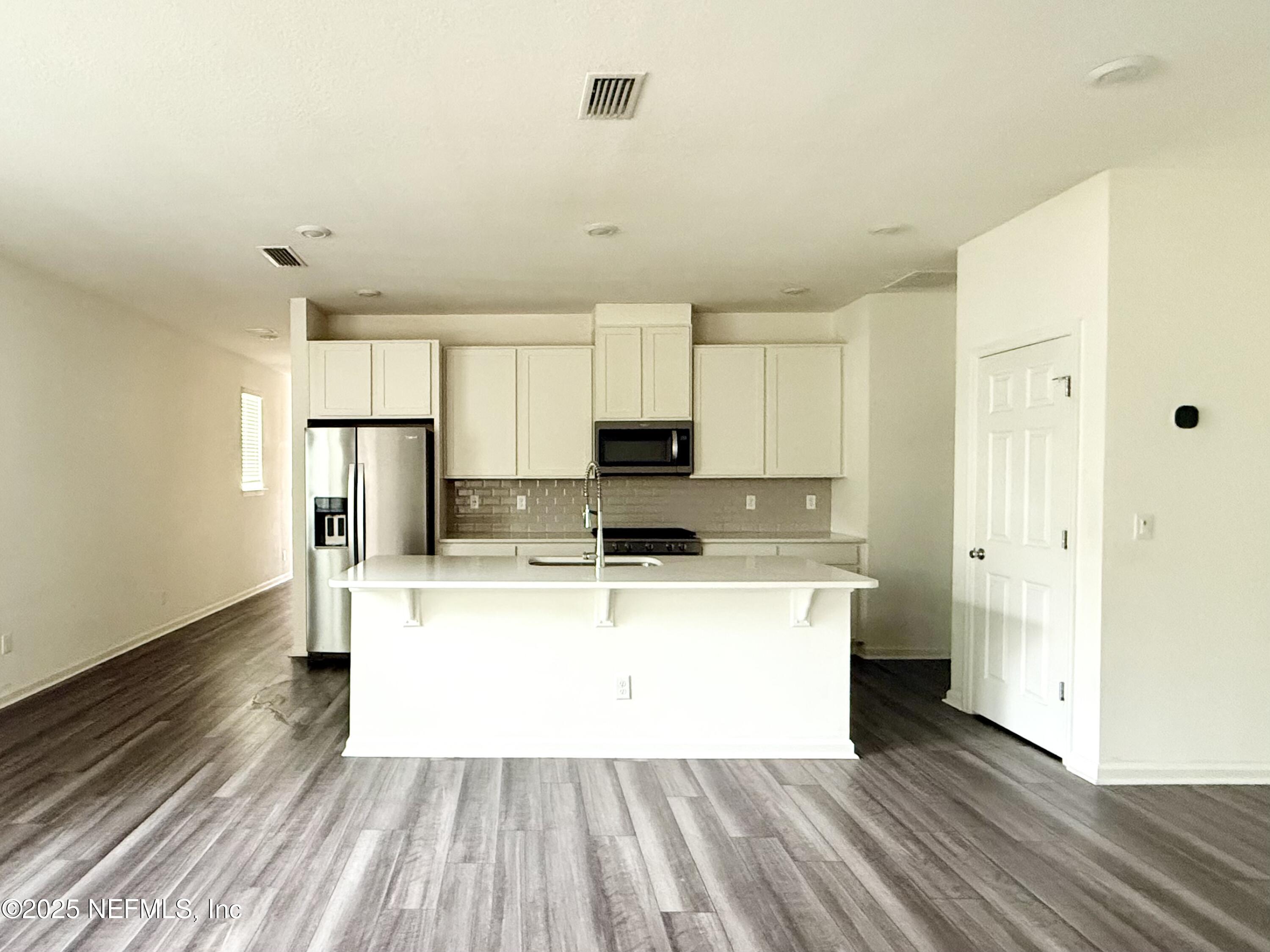 216 Rambling Brk Trail St. Johns, FL 32259 - Photo 8 of 24 a view of a kitchen with a sink refrigerator and wooden floor