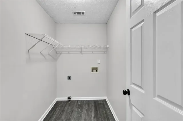 a large kitchen with stainless steel appliances granite countertop a sink a stove a refrigerator and white cabinets