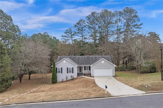 a front view of a house with a yard and trees