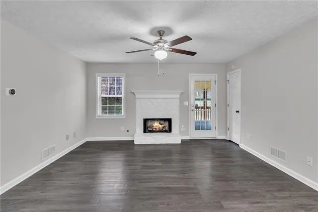an empty room with windows and fireplace