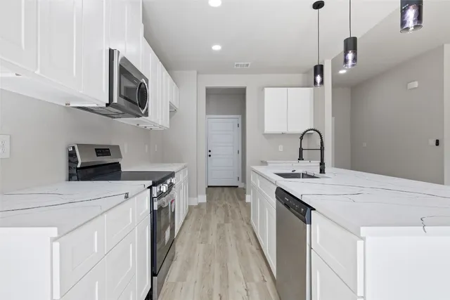 a kitchen with a sink a microwave and cabinets
