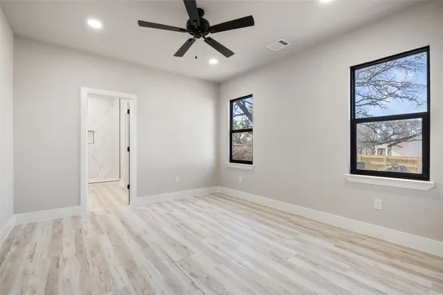 a view of empty room with wooden floor