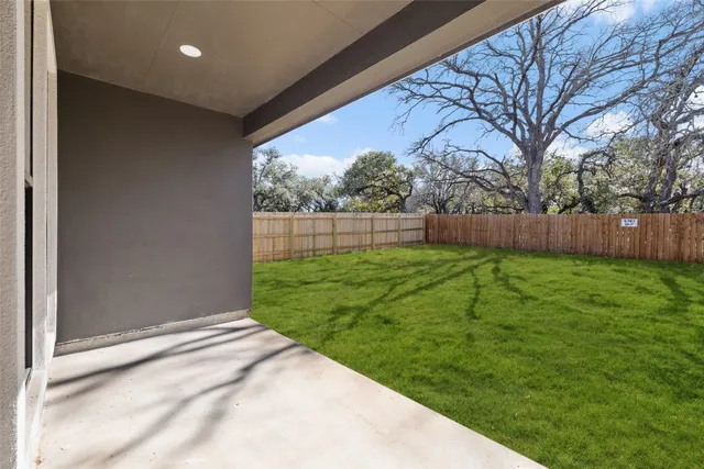 a view of backyard with wooden fence