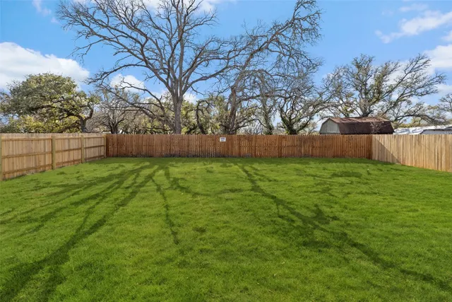 a view of a backyard with large trees