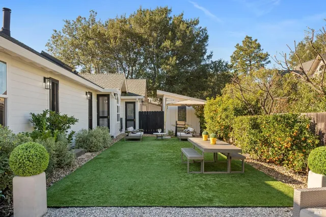 a white bench sitting in front of a house with a big yard
