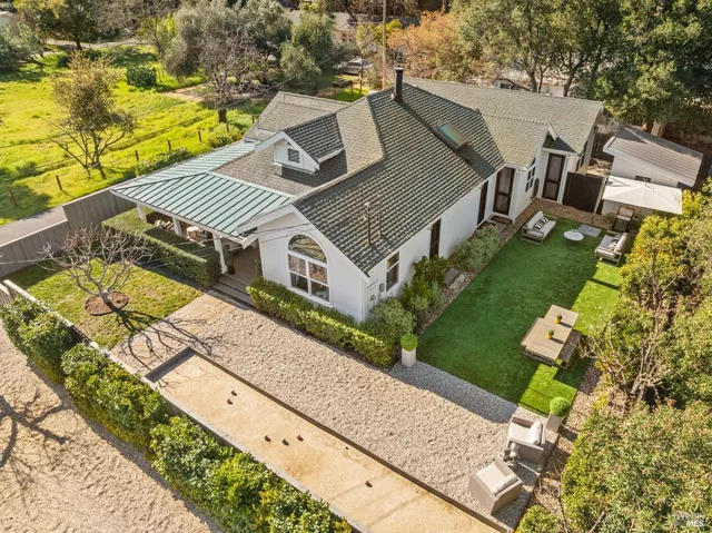 an aerial view of a house with a garden and trees all around