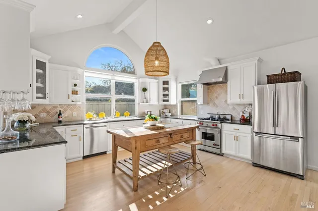 a kitchen with stainless steel appliances granite countertop a sink stove and refrigerator