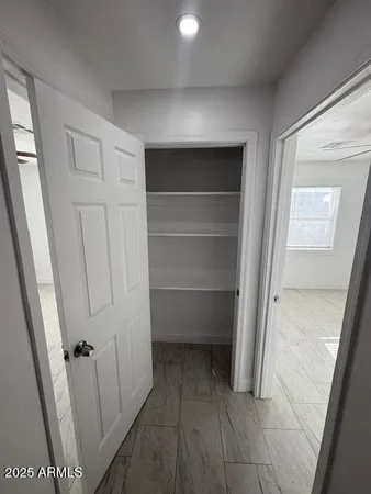 a view of walk in closet with empty racks