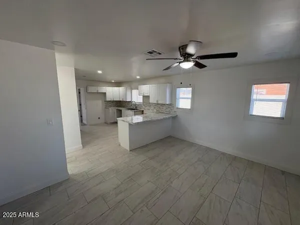 a view of a kitchen with a stove cabinets a ceiling fan and wooden floor
