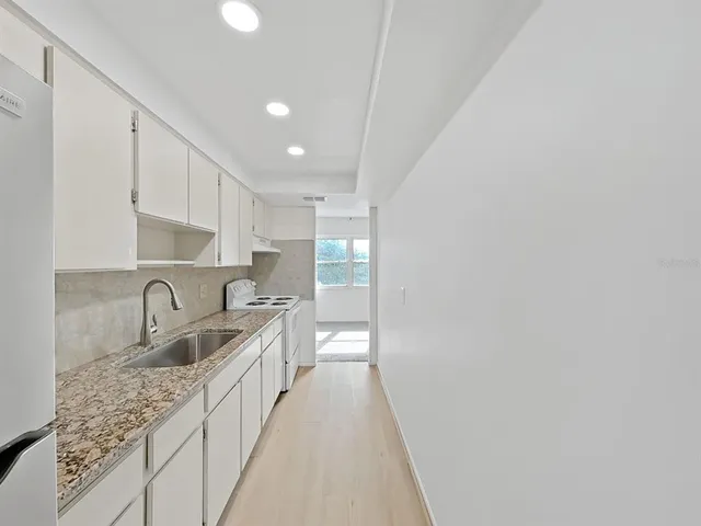 a kitchen with granite countertop a sink and cabinets