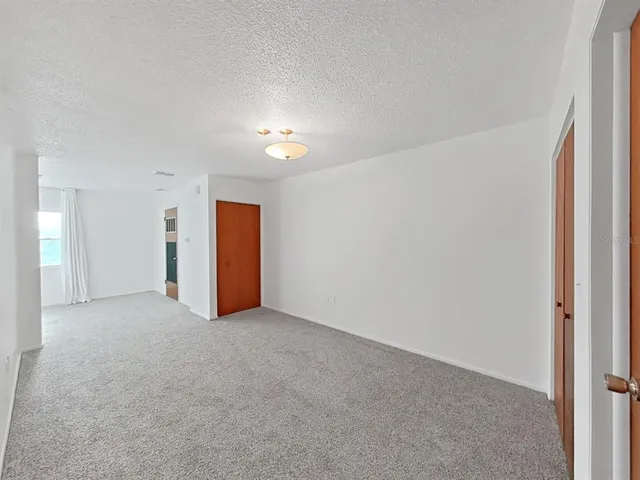 an empty room with closet and a window