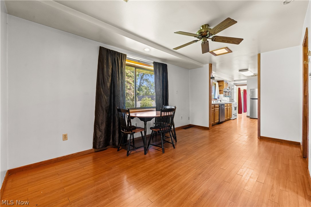 409 Edith Avenue Akron, OH 44312 - Photo 14 of 45 Spacious interior featuring wood-finish flooring, a window with exterior views, and a ceiling fan with integrated lighting
