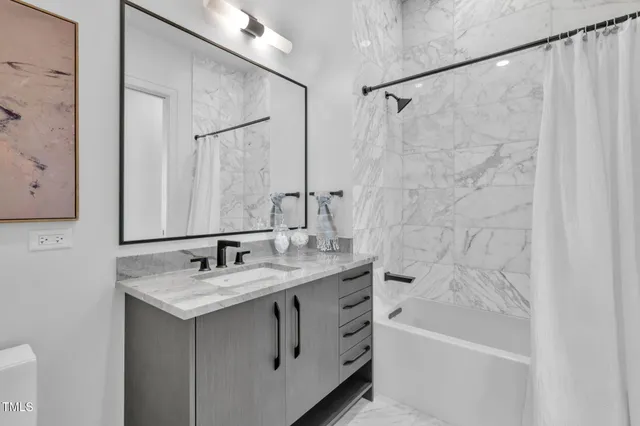 a bathroom with a granite countertop shower and a toilet
