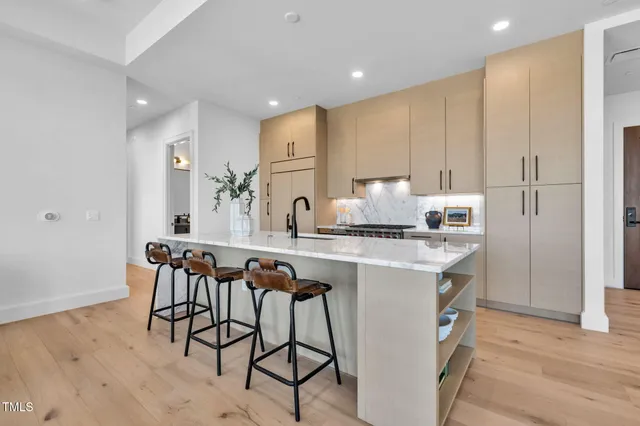 a large kitchen with stainless steel appliances granite countertop a lot of counter space and wooden floors
