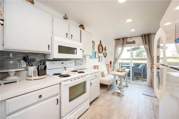 a kitchen with stainless steel appliances white cabinets a sink a stove a refrigerator and cabinets