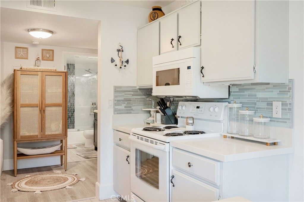 68 Corniche Drive, Unit B Dana Point, CA 92629 - Photo 17 of 35 a kitchen with kitchen island granite countertop white cabinets and white appliances