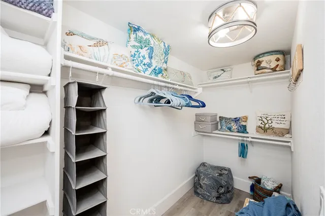 a view of walk in closet with clothes and shoes